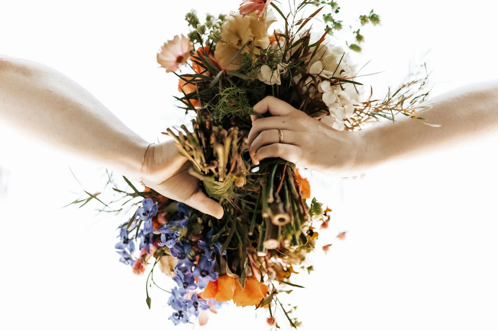 A loose, wild bouquet held out between two hands